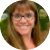 Circular profile picture of a woman with brown hair and glasses smiling at the camera.